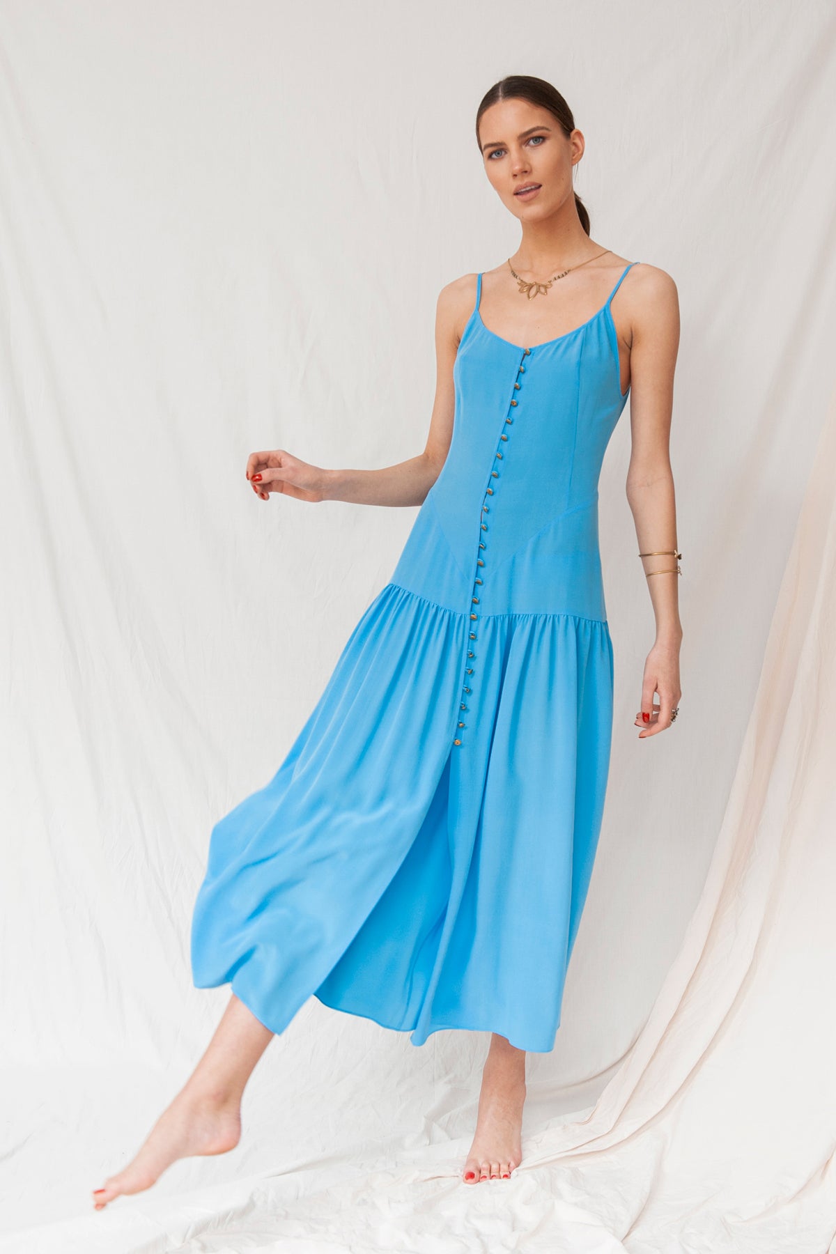 Sky blue handmade maxi dress with thin straps and a button-front, made from sustainable organic fabric.
