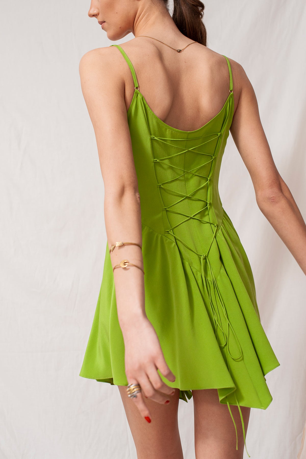 Sustainable handmade bright green Celina mini dress with adjustable lace-up back and organic eco-friendly fabric.