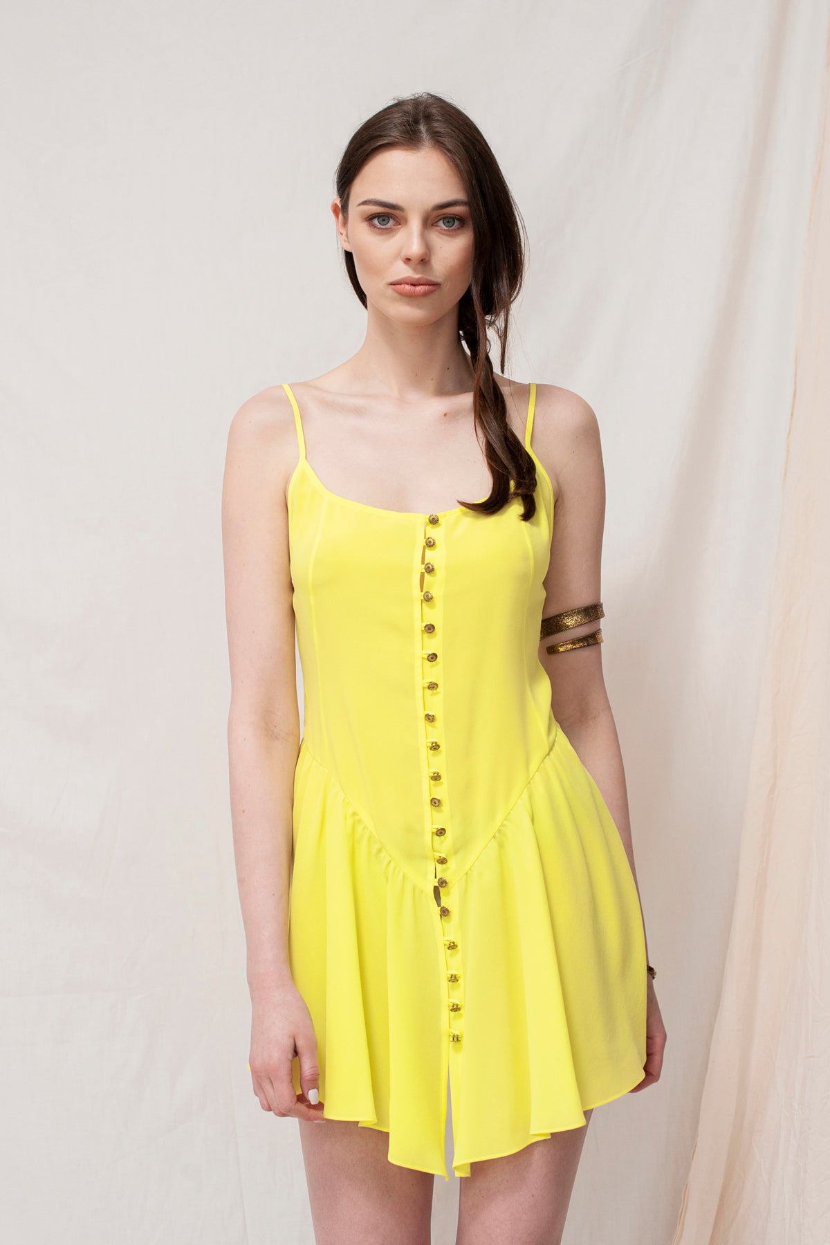 Yellow sustainable handmade mini dress with thin straps and front button detailing, eco-friendly and organic fabric.