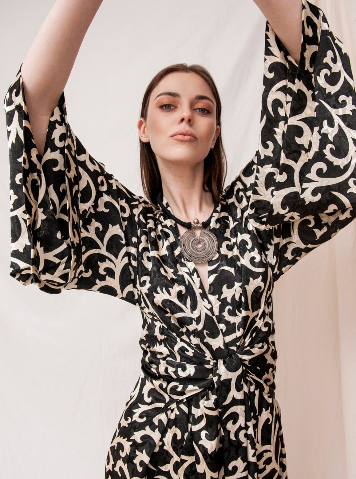 Black onyx kimono with wide sleeves and bold white swirl pattern, handmade sustainable fabric.