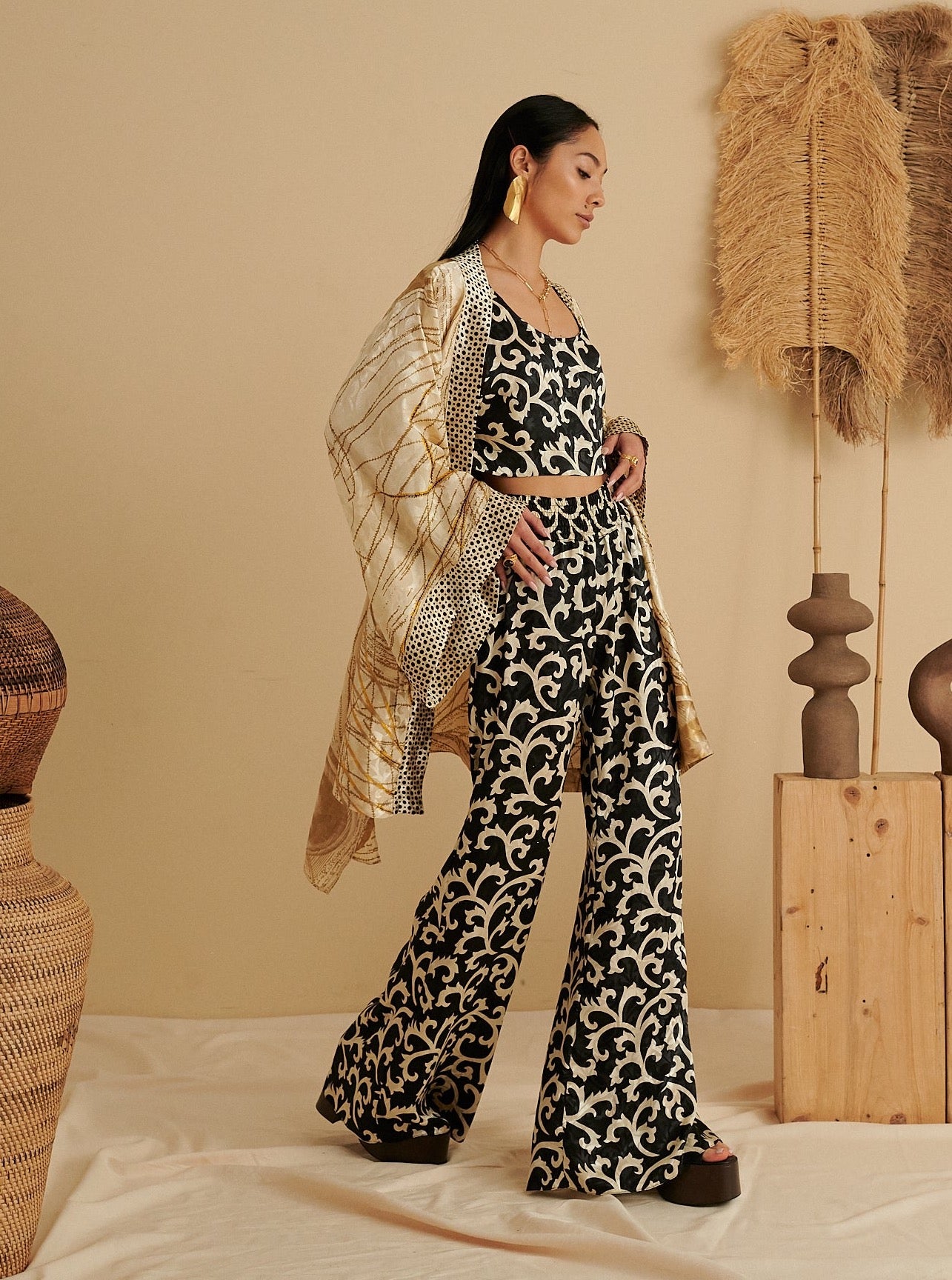 Black and white organic cotton jumpsuit with floral pattern, paired with a sustainable, handmade golden kimono draped over.